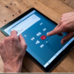 A man listens to a recording on a tablet as an accessibility features provided at the Library.