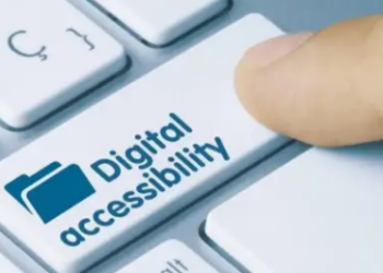 A person's index finger rests on a key with a digital accessibility icon on it.