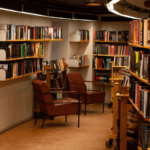 A dimly lit library space with various publishers books arranged on the shelves.